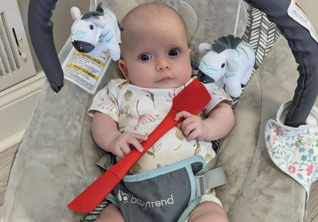 Infant holding spatula